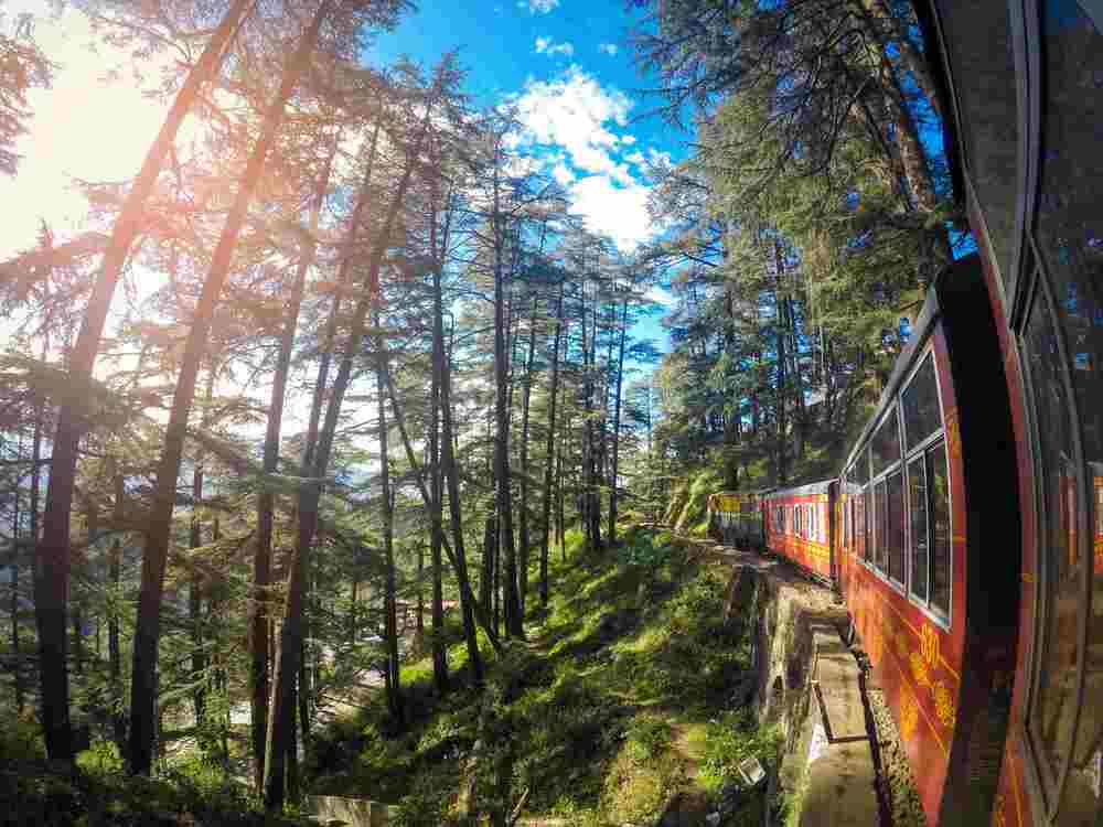 A green valley with trekkers in the Himalayas.